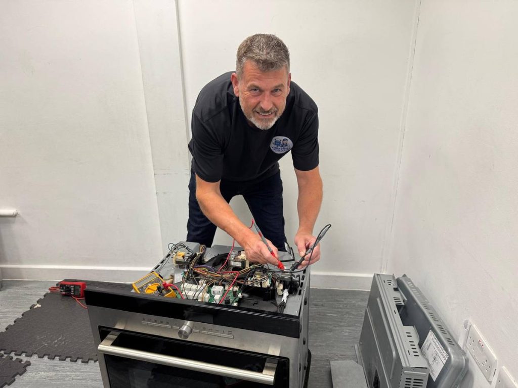 Adam Henderson carrying out diagnostic tests on a built-in electric oven